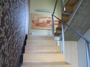 Neo-baroque, opaque gold-colored motifs contranst with the modernist stair trim. Staircase in the early 21st century home. L. Preišegalavičienė photo, 2013